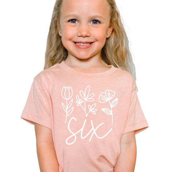 Side angle view of mauve floral sixth birthday shirt for toddler girls