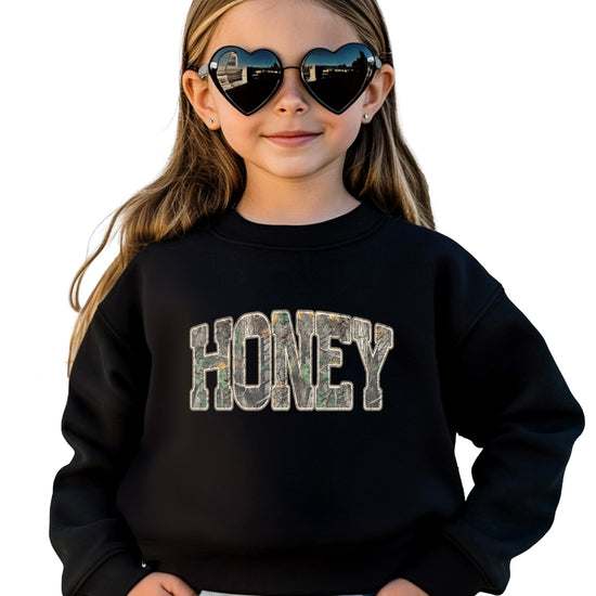Close-up of Honey Camo graphic design on army green sweatshirt