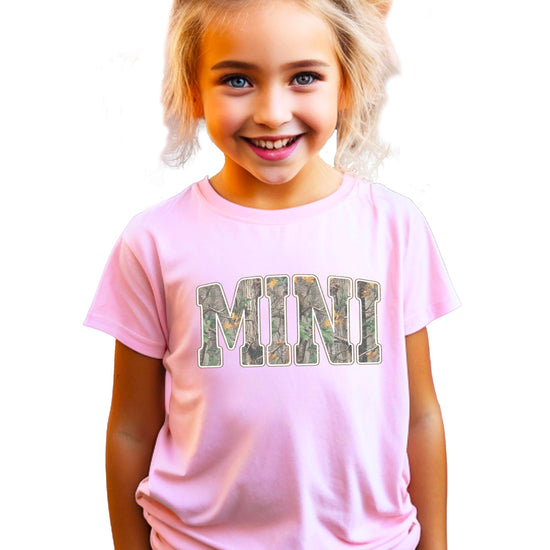 Side by side comparison of mama and mini camo matching shirts showing size difference