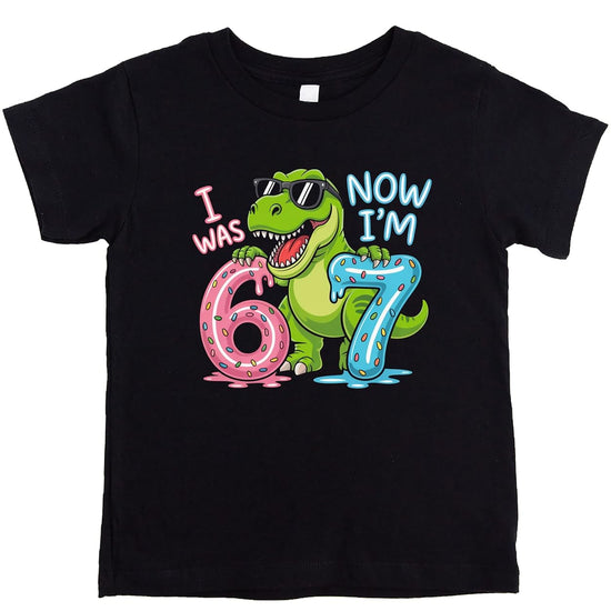 Pink I Was 6 Now I'm 7 dinosaur birthday shirt with T-Rex in sunglasses holding donut numbers