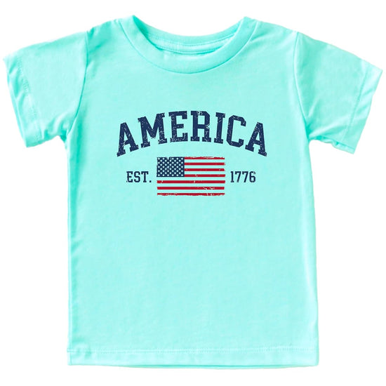 America Est 1776 patriotic shirt with distressed American flag and collegiate arch lettering in natural color