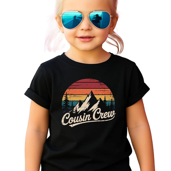 Cousin Crew shirt flat lay showing vintage mountain sunset graphic and script text