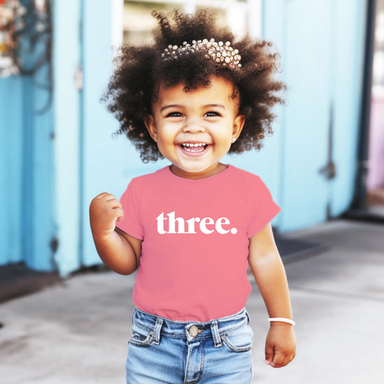 Close-up of Three period text design on toddler birthday shirt
