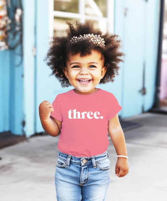 Close-up of Three period text design on toddler birthday shirt