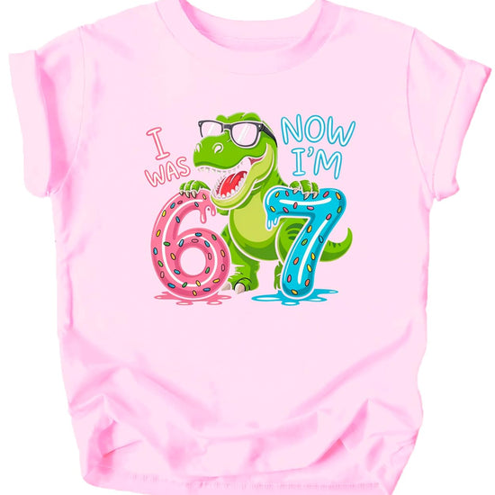 Close-up of I Was 6 Now I'm 7 shirt design showing dinosaur in sunglasses with donuts