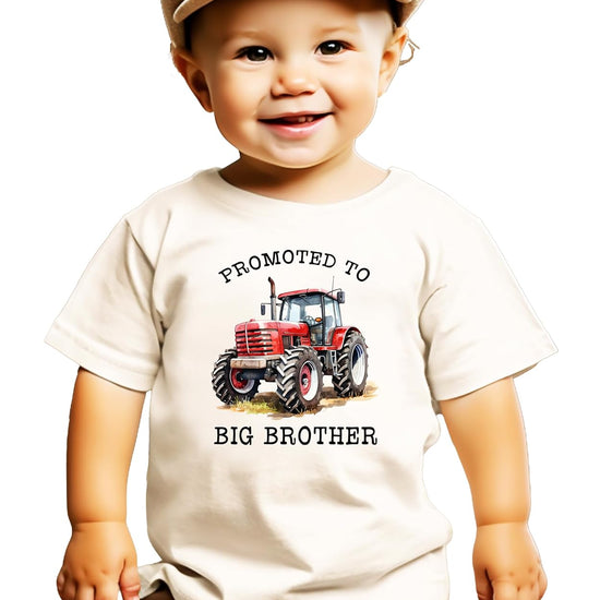 Close-up view of red tractor graphic with Promoted to Big Brother lettering on natural shirt