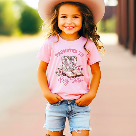 Side view of girls Big Sister shirt with western themed cowgirl boots print