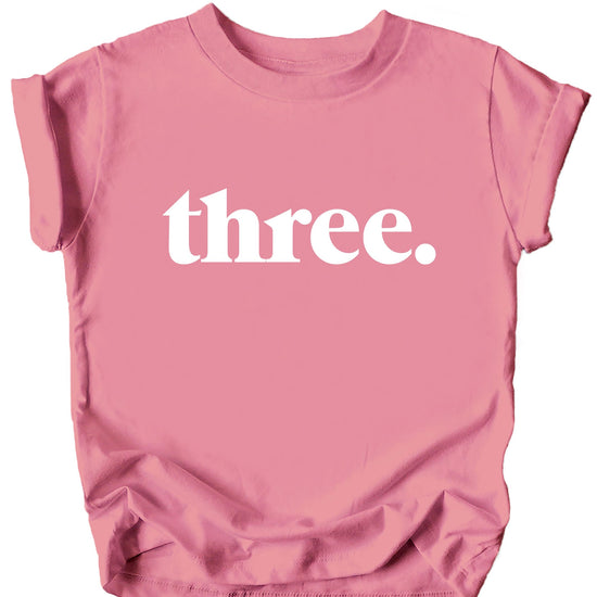 Close-up view of Three Period typography on black toddler birthday shirt