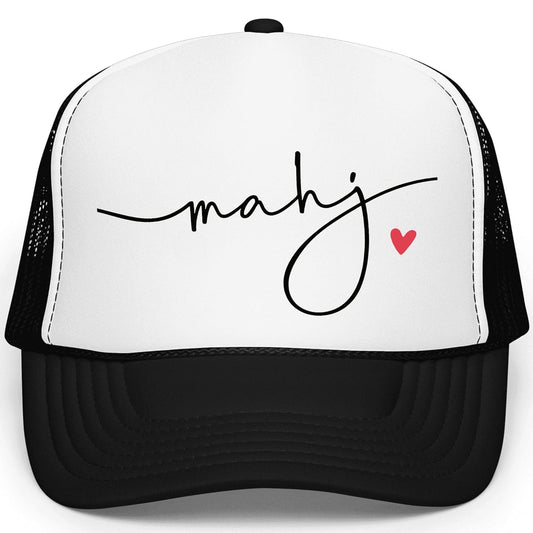 White mahj trucker hat with red heart detail worn by woman with blonde hair