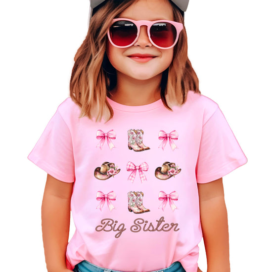 Western big sister tee with boots hats and bows graphic displayed on product model
