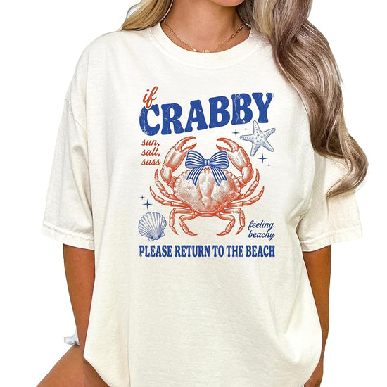 Woman wearing ivory crab graphic tee with coastal beach design and coquette bow