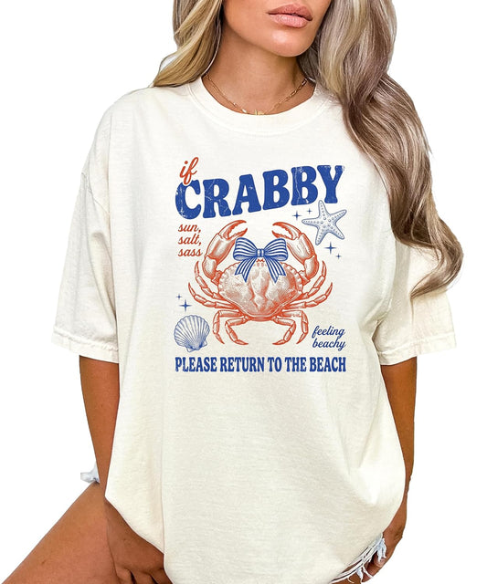 Woman wearing ivory crab graphic tee with coastal beach design and coquette bow