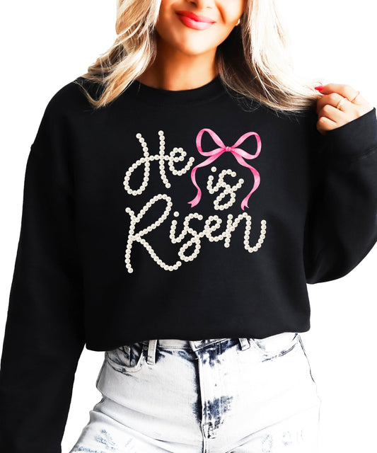 Close-up view of pearl He Is Risen text with decorative bow on green pullover sweatshirt