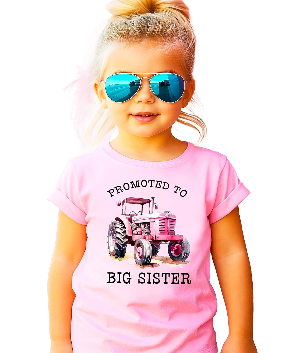 Close-up of pink tractor graphic with promoted to big sister text on shirt