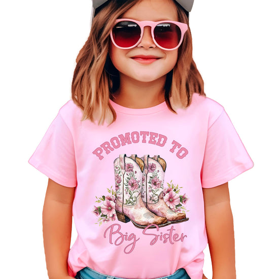 Close-up view of Big Sister shirt showing western cowgirl boots and flower graphics