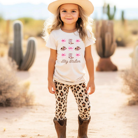Big sister western shirt detail shot highlighting pink cowgirl boot and hat elements