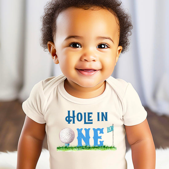 Baby bodysuit laid flat displaying full golf-themed birthday one-piece design