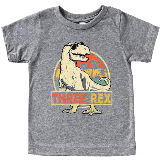 Close-up of Three Rex birthday shirt design showing cartoon dinosaur and text