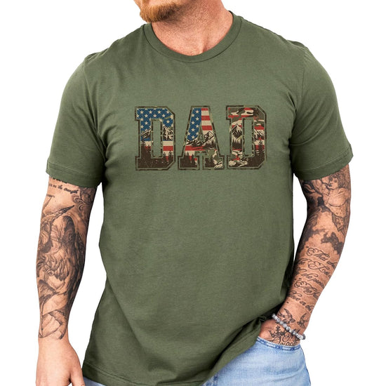 Patriotic dad shirt laid flat showing full DAD design with woodland camo and flag elements