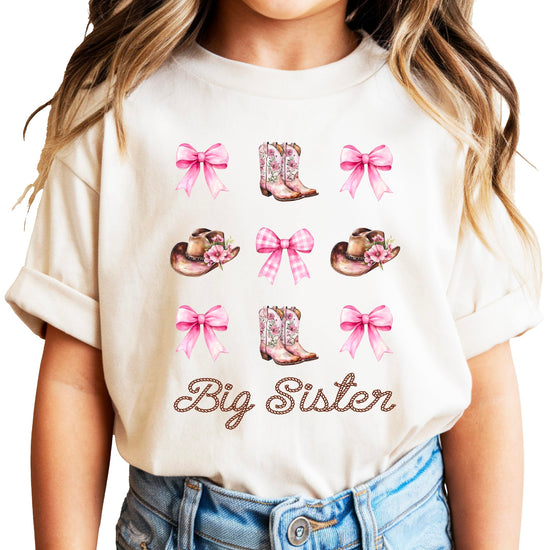 Big sister cowgirl shirt flat lay showing full western-themed sibling announcement design