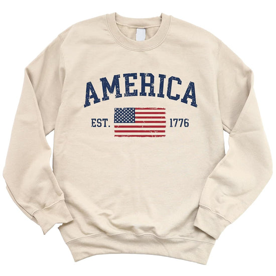 America Est 1776 sweatshirt flat lay displaying vintage patriotic graphic and crewneck style