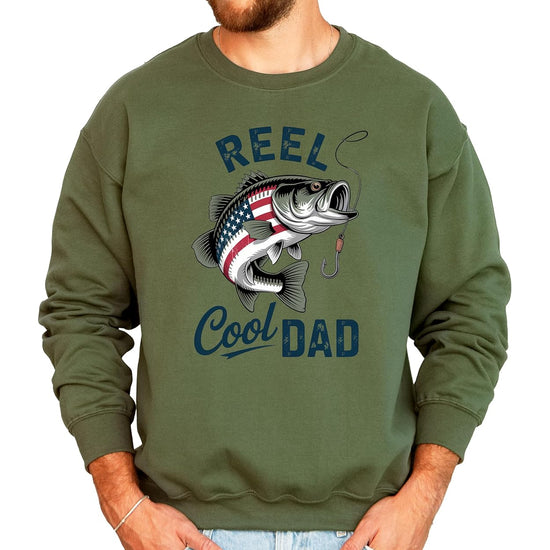Reel Cool Dad fishing sweatshirt in sand color with patriotic bass graphic on male model