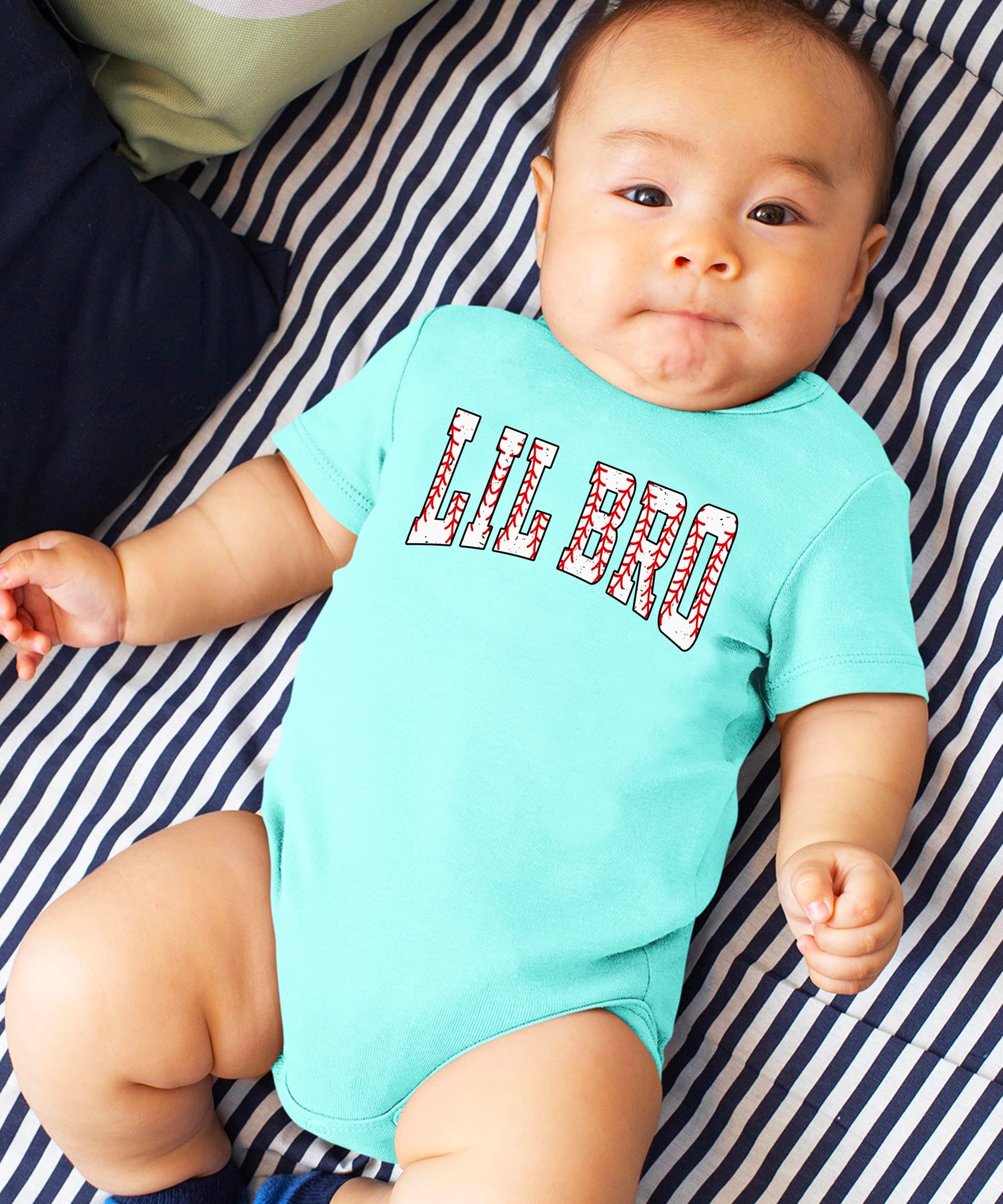 Detail shot of baseball stitching design elements on Lil Bro toddler bodysuit