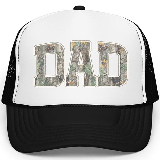 Close-up of woodland camouflage Dad lettering with white outline on trucker hat