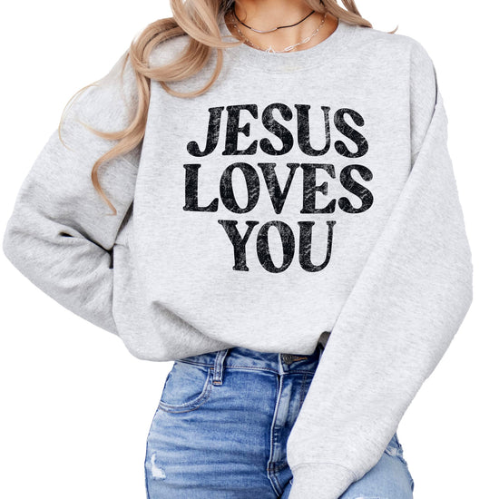 Close-up of Jesus Loves You distressed text design on sweatshirt