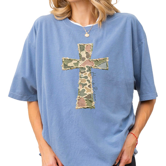 Women's blue He Is Risen cross graphic t-shirt with patchwork design on white background