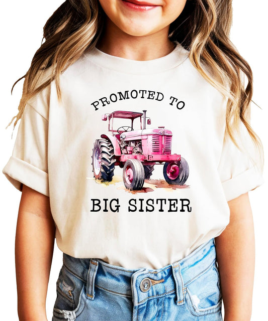 Pink promoted to big sister tractor shirt on young girl outdoors