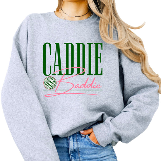 Close-up of Caddie Baddie text design on green women's golf sweatshirt