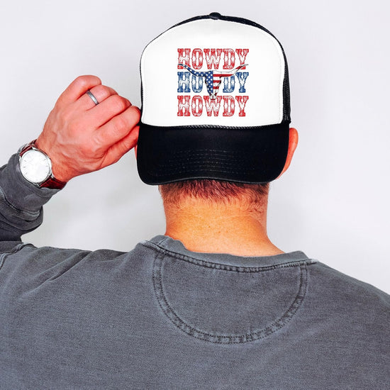 Model wearing white and black patriotic western trucker hat outdoors