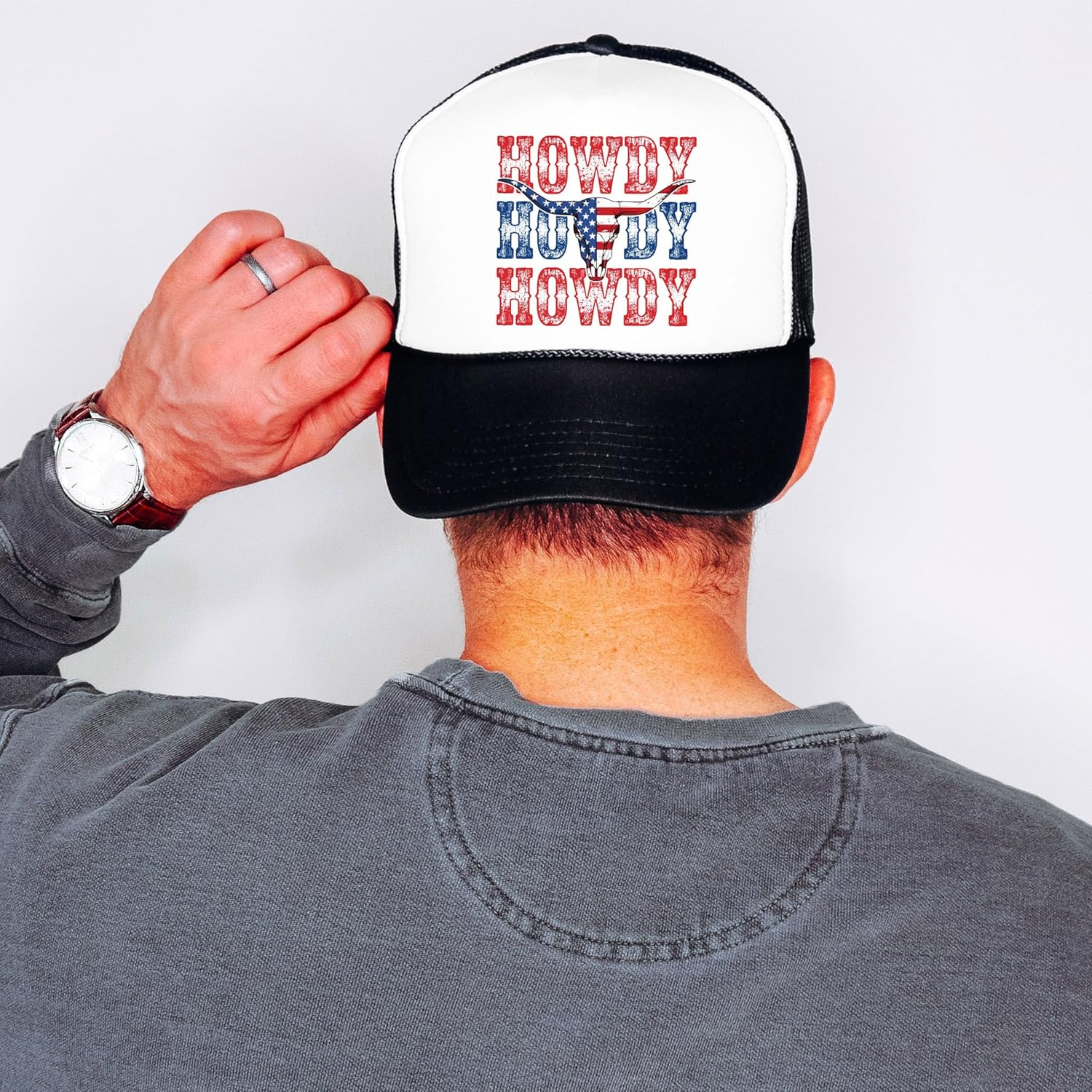 Model wearing white and black patriotic western trucker hat outdoors