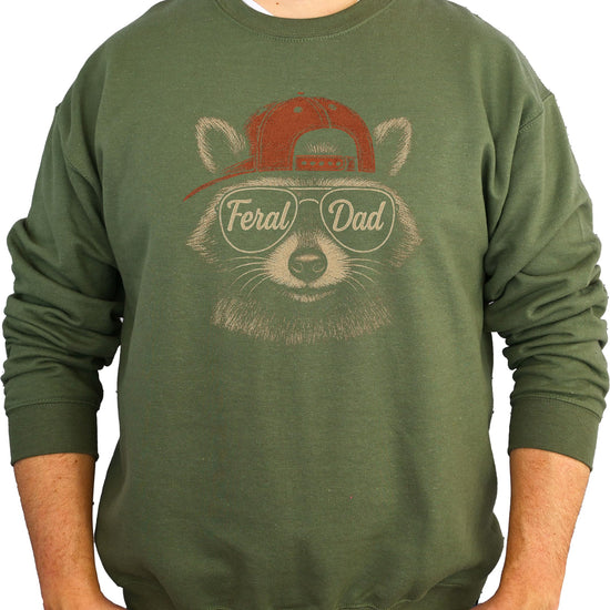 Black sweatshirt displaying humorous Feral Dad raccoon illustration with text