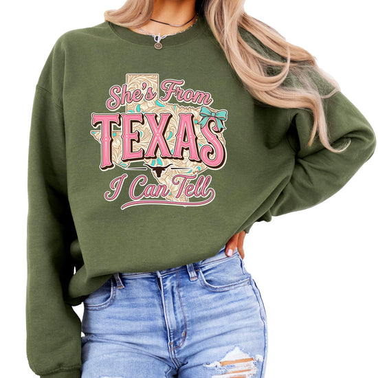 Flat lay of She's From Texas sweatshirt showing full design and western typography