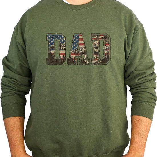 Sand colored patriotic dad sweatshirt flat lay showing American flag camo mountain graphic