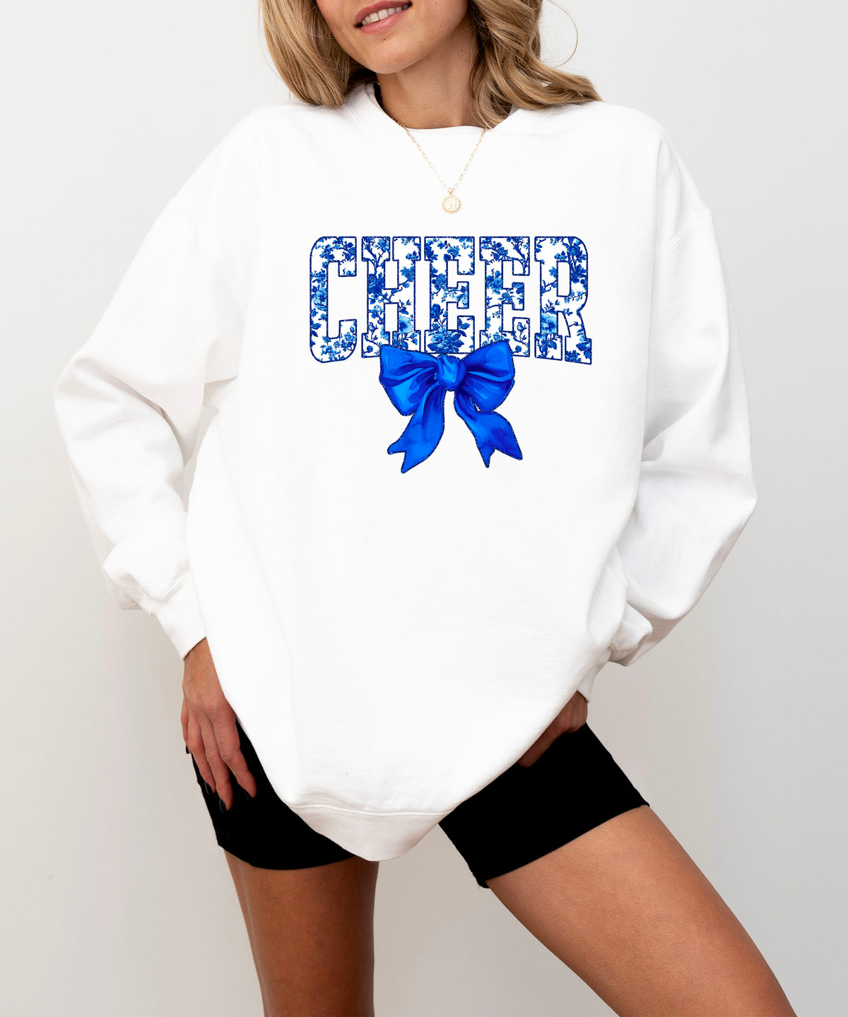 White cheer crewneck sweatshirt with blue floral CHEER lettering and coquette bow
