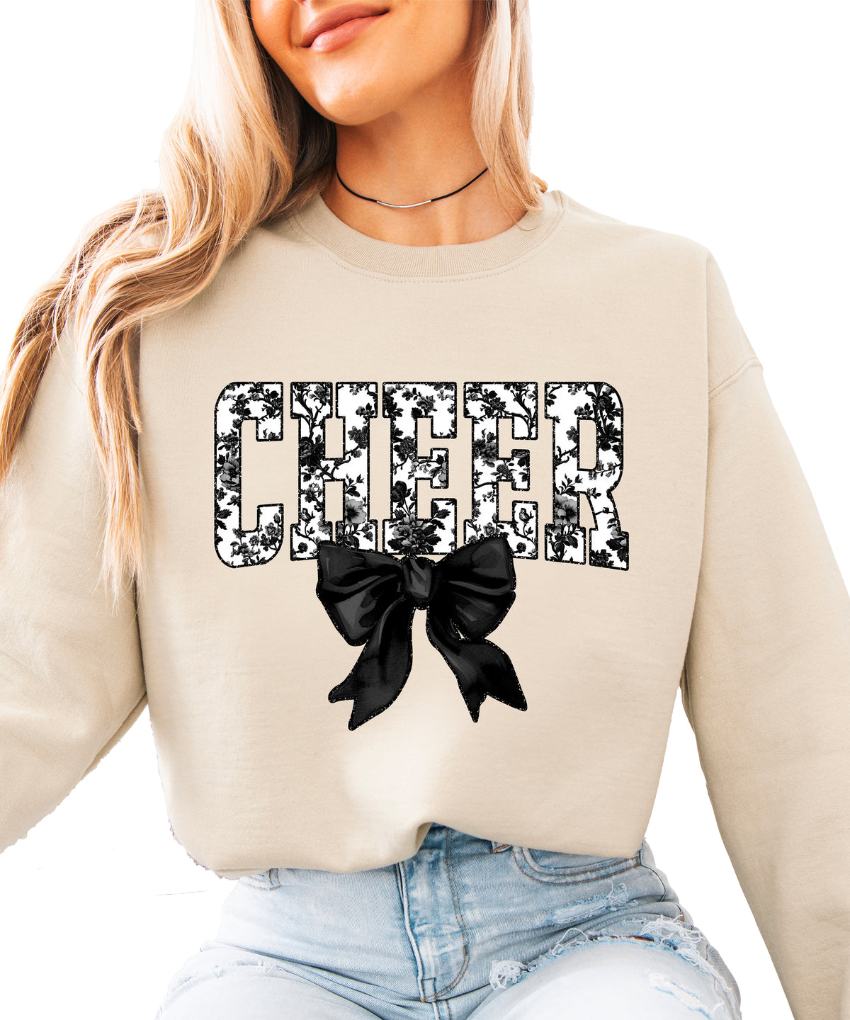Sand crewneck sweatshirt with black floral CHEER varsity letters and coquette bow, front view