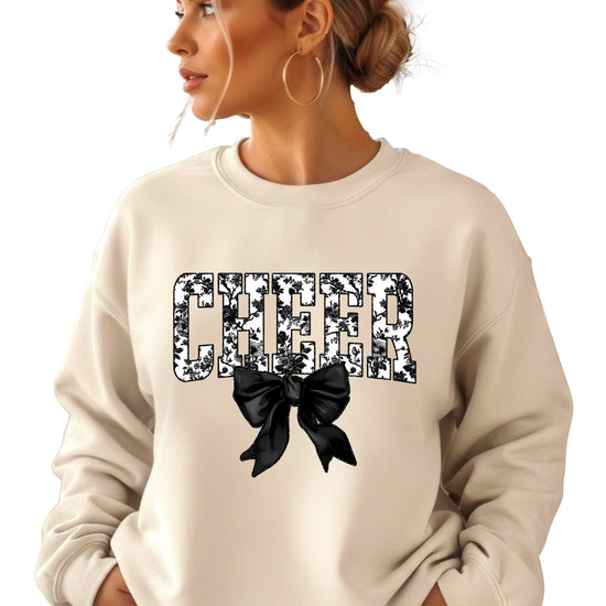 Sand cheer sweatshirt with black floral bow design, detail view