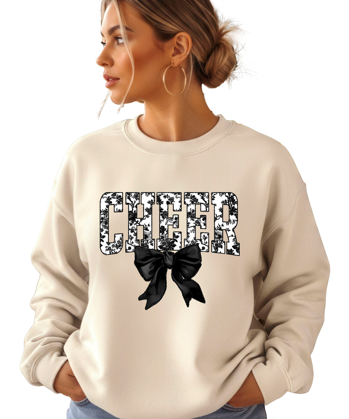Sand cheer sweatshirt with black floral bow design, detail view