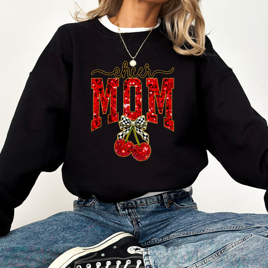 Black Cheerleader Mom crewneck sweatshirt with ink-printed faux sequin cheer script, MOM lettering and cherry coquette bow, styled detail view