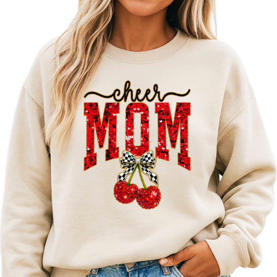 Sand Cheerleader Mom crewneck sweatshirt with ink-printed faux sequin cheer script, MOM lettering and cherry coquette bow, close-up of the ink-printed design