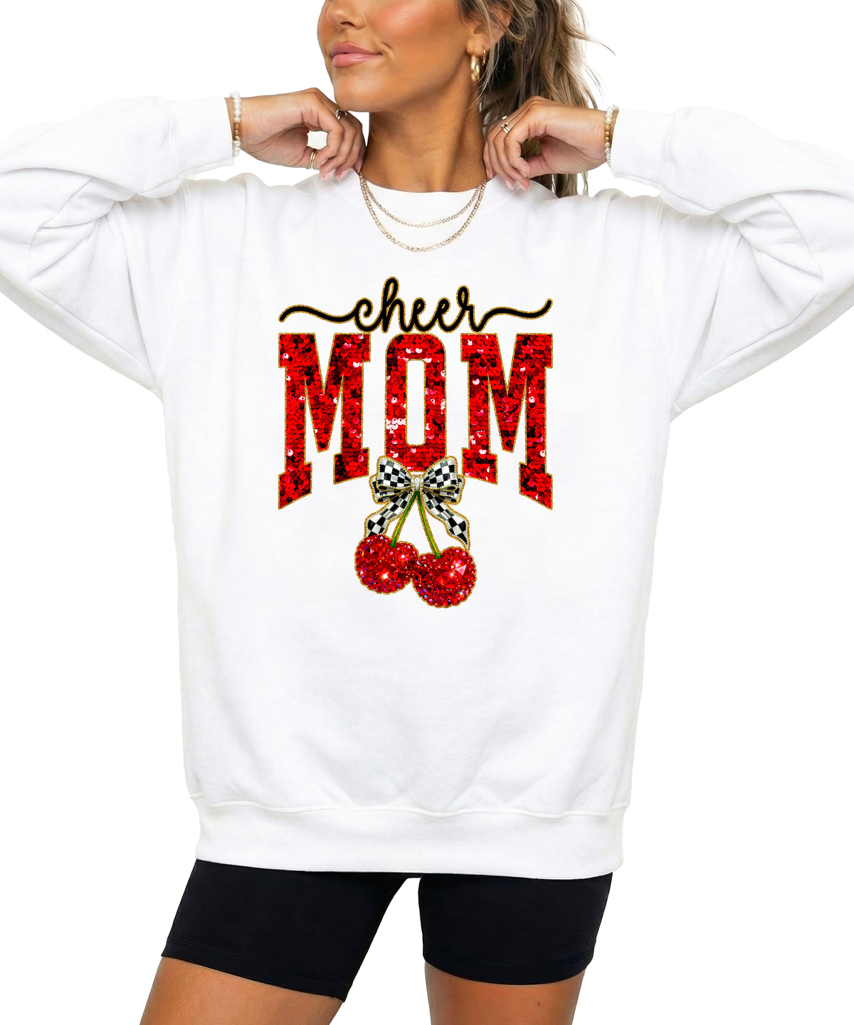 White Cheerleader Mom crewneck sweatshirt with ink-printed faux sequin cheer script, MOM lettering and cherry coquette bow, styled detail view