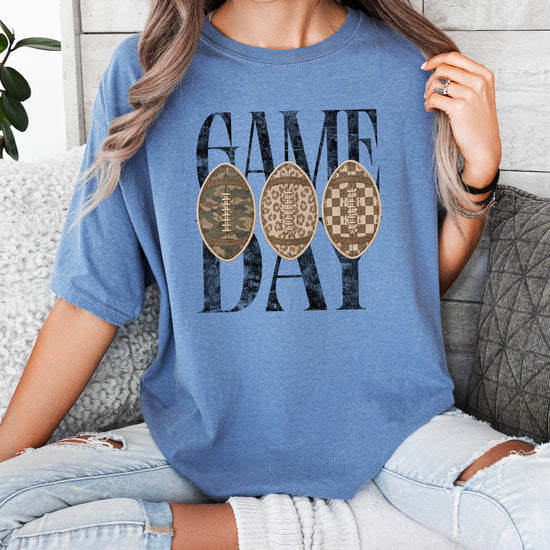 Game Day football shirt for women in Blue Jean, lifestyle view worn by a model, Comfort Colors 1717 garment-dyed heavyweight cotton tee by Olive Loves Apple