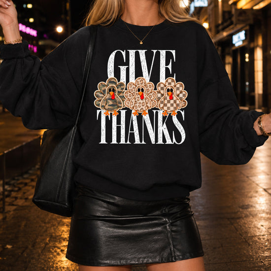 Give Thanks Thanksgiving sweatshirt for women in Black with camo, leopard and checkered turkeys
