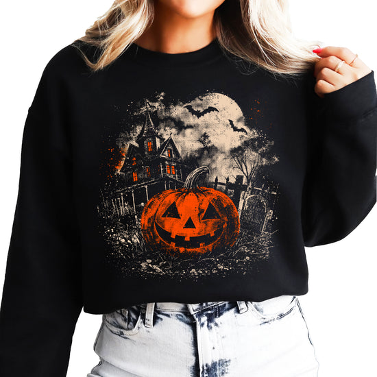 Black crewneck sweatshirt with distressed vintage jack o lantern, haunted house and bats Halloween graphic, front view