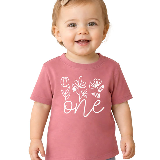 Floral One first birthday shirt for baby girls in white on mauve, front view