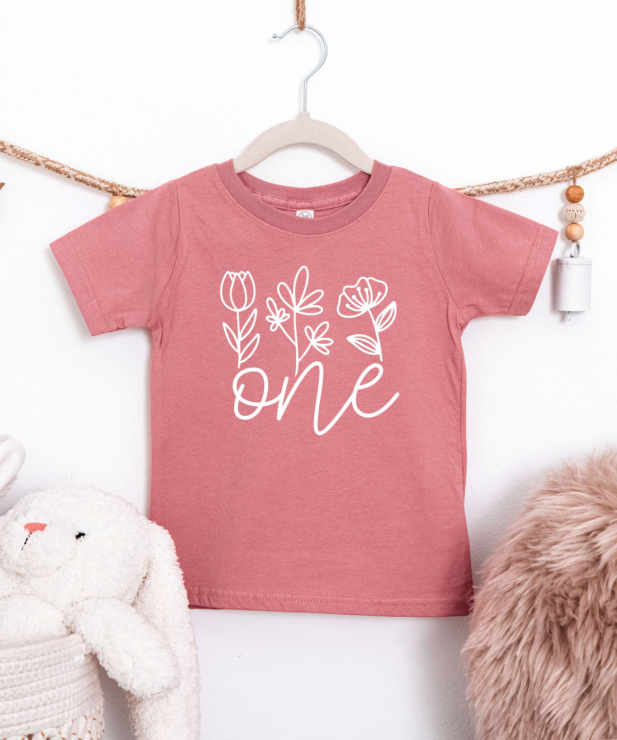 Floral One first birthday shirt for baby girls in white on mauve, second view