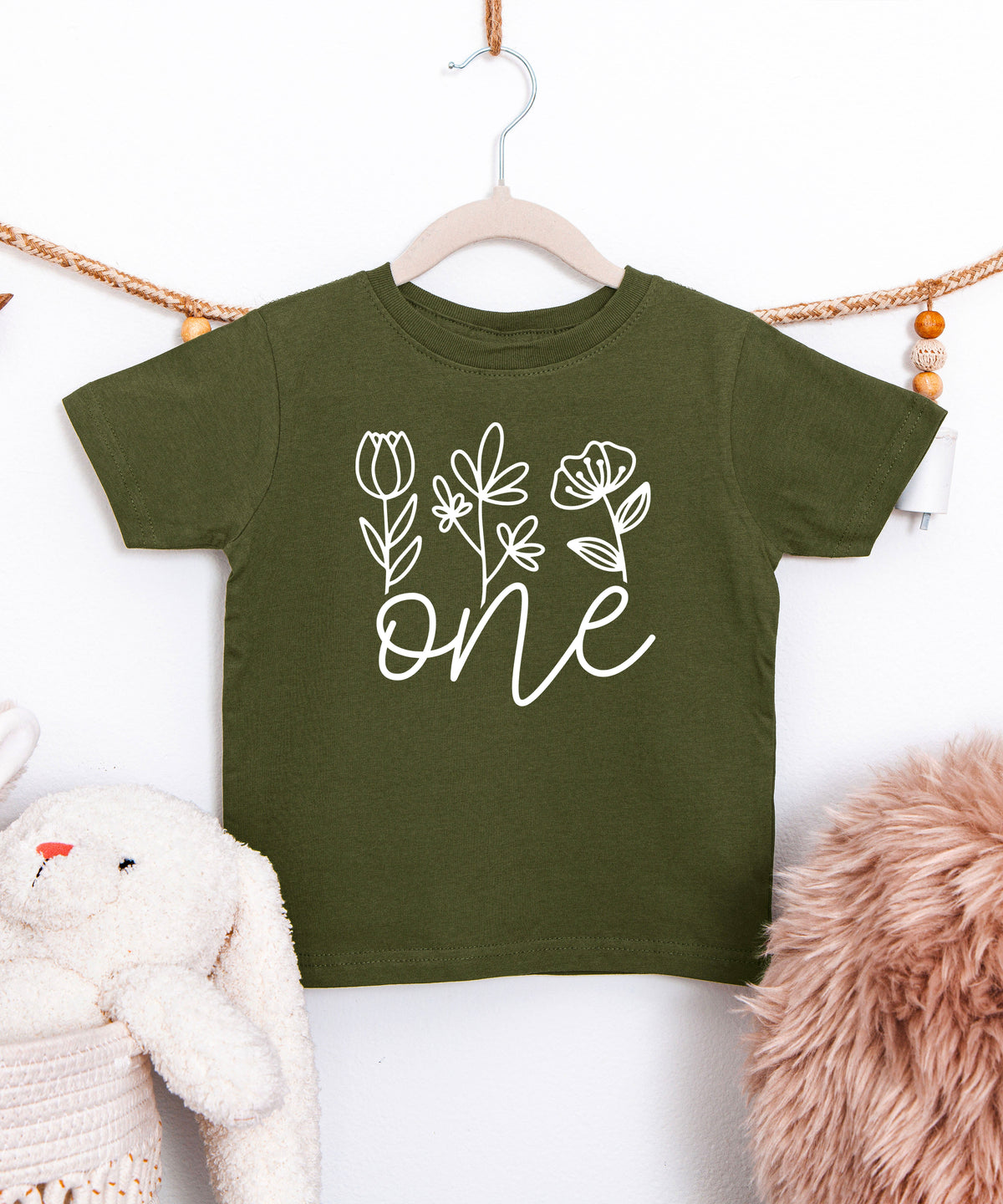 Floral One first birthday shirt for baby girls in white on military green, second view